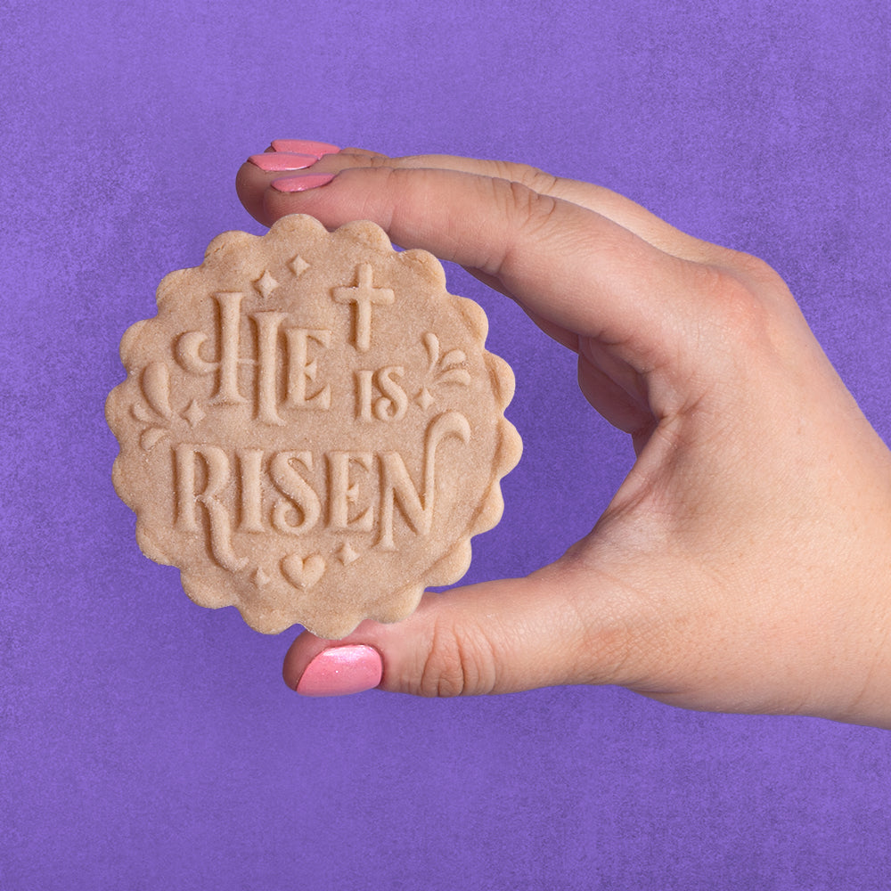 Embossed sugar cookie that says He is Risen